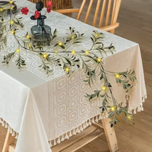 Detail of 180cm artificial olive vine garland with LED lights on a decorative table.