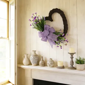 Ghirlanda a forma di cuore con fiori viola appesa su una parete di legno rustico
