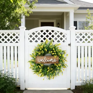 Yellow floral spring wreath with wooden welcome sign on a white garden gate detail