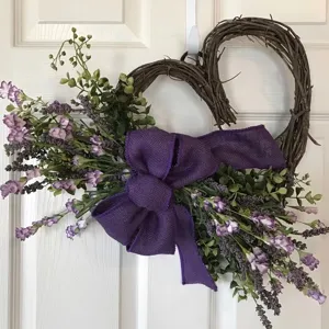 Ghirlanda di vite a cuore con fiori di lavanda e un grande fiocco di tela color viola per porta.
