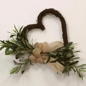 Rustic heart-shaped grapevine wreath decorated with olive branches and burlap bow for home decor