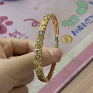 Squisito bracciale vintage placcato oro con trama geometrica e pietre di cristallo alternate.