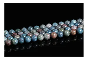 Close-up macro view of polished round natural gemstone beads in mixed blue and red hues