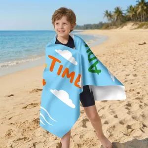 Kind am Strand eingehüllt in ein blaues Mikrofaser-Strandtuch mit Wolken- und 'TIME'-Aufdruck