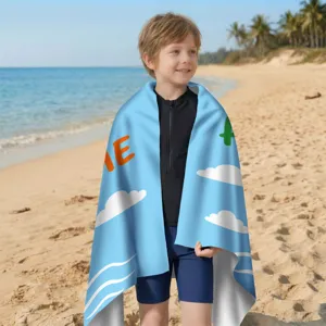 Kind in einem schnelltrocknenden Mikrofaser-Strandtuch an einem sonnigen Strand.
