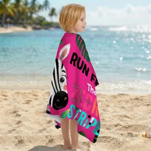 Detailansicht eines rosa Kinder-Badetuchs aus Mikrofaser mit Zebradruck am Strand