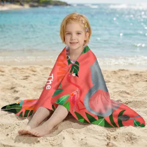 Kind in ein schnelltrocknendes Mikrofaser-Strandtuch mit Flamingo-Print am Strand gehüllt.