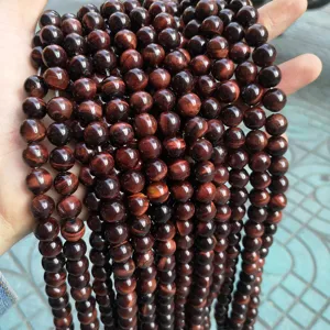 Macro view of natural red tiger eye stone beads showing smooth texture and cat-eye effect