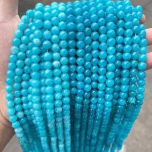 Gros plan de perles rondes en calcédoine bleu vif pour la fabrication de bijoux