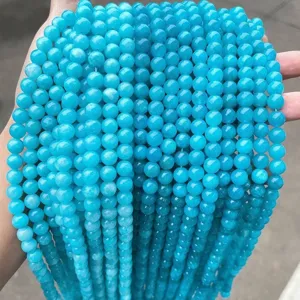 Détail rapproché de perles rondes en calcédoine bleue lisse pour bijoux artisanaux