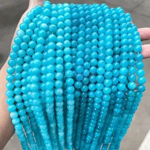 Gros plan de perles rondes en calcédoine bleu vif pour la fabrication de bijoux DIY