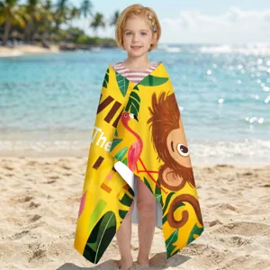 Kindermodell mit leuchtend gelbem Mikrofaser-Strandtuch mit Affenmuster an einem Strand.