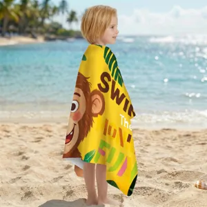 Kind eingewickelt in ein schnell trocknendes Mikrofaser-Strandtuch mit Affen-Motiv