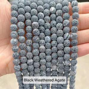Detailed macro view showing the cracked texture of matte black weathered agate beads.