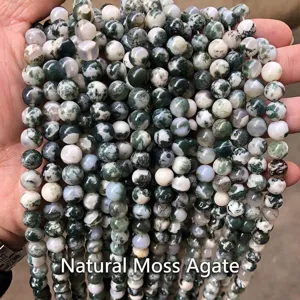 Vista dettagliata di perle tonde in agata dendritica naturale per la creazione di gioielli DIY.