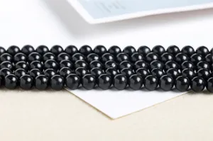 Close-up macro view of natural black round shungite stone beads for DIY jewelry making