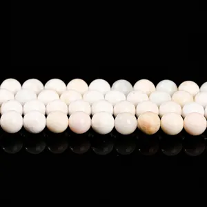 Polished white opal round beads for DIY jewelry making with reflective black background
