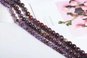 Detailed macro view of polished purple phantom crystal beads for handmade jewelry