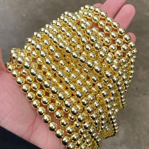 Close-up detail of shiny gold plated round hematite beads for DIY jewelry making