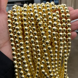 Close-up of electroplated gold hematite round bead strands showing metallic mirror finish