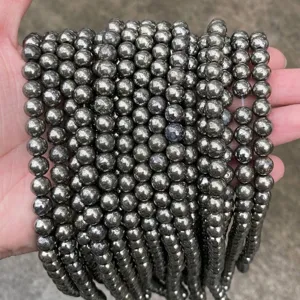 Detalle de cerca de cuentas redondas de pirita natural para crear accesorios de joyería artesanal
