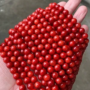 Gros plan de perles rondes en calcédoine cornaline rouge vif pour création bijoux