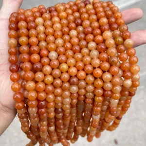 Close-up detail of natural red aventurine jade round loose beads for DIY jewelry making.