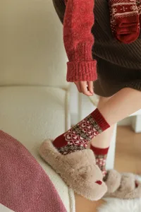 Close-up detail of cozy retro Fair Isle wool blend crew socks in festive red and brown.