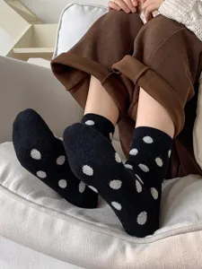 Close-up of women's warm winter polka dot mid-tube socks, soft cashmere blend, casual style.