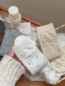 Close-up detail of cozy knit socks featuring gentle sweet floral patterns for daily wear.