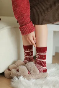 Close-up detail view of women winter red wool Fair Isle pattern mid-tube socks with soft slippers.