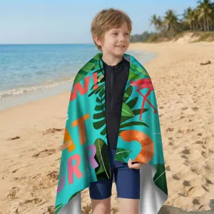 Kind eingewickelt in ein buntes, schnell trocknendes Mikrofaser-Strandtuch am Strand