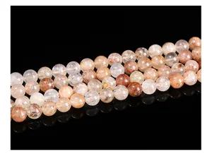 Close-up view of natural red rutilated quartz round beads with intricate inner rutile threads