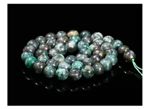 Detalle macro de cuentas redondas de mineral de hierro verde natural para joyería DIY