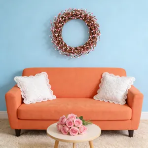 Heart-shaped pink and white floral wreath displayed on a light blue wall in a living room