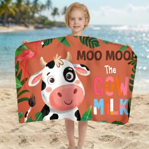 Kind hält ein Mikrofaser-Strandtuch mit süßem Cartoon-Kuh- und Flamingo-Druckmotiv