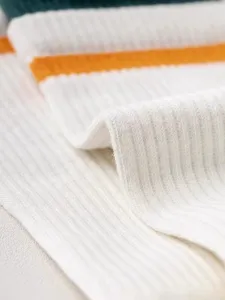 Close-up detail of ribbed knit fabric texture with colorful stripes for apparel or socks.