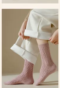 Detailansicht von dicken Damen-Wollsocken in Rosa mit Zopfmuster und kuscheligem Plüschfutter.