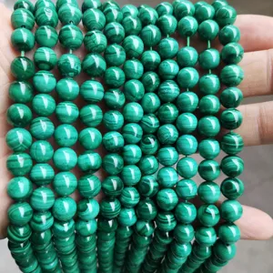 Macro view of polished green malachite round beads showing unique banded patterns