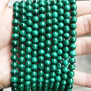 Detailed macro view of natural green malachite round loose beads with striped texture