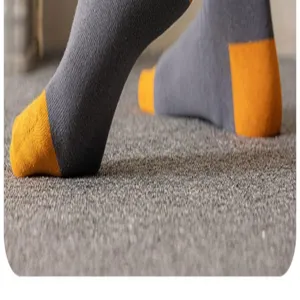 Close-up detail view of men's gray mid-calf socks featuring contrast orange toe and heel design.