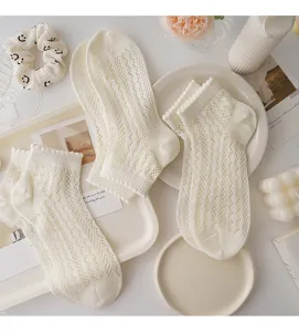 Detailed view of white hollow-out mesh lace short socks, sweet Japanese style for summer.