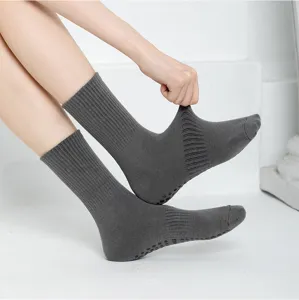 Detail view of grey non-slip yoga socks featuring bottom grip dots and stretchy ribbed fabric.