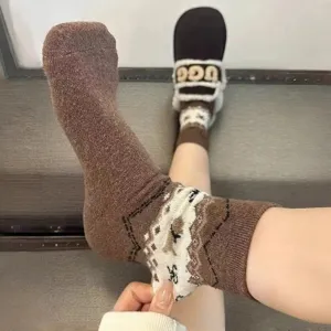 Detail view of brown Fair Isle winter warm knit mid-calf socks with cute puppy patterns.