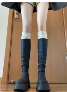 Detailansicht von Ballettrand Spitzenbeinlingen geschichtet mit schwarzen Stiefeln formend.