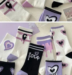 Schöne lila und weiße Baumwollsocken mit bunten Herzmustern und stilvollem Love-Druck.