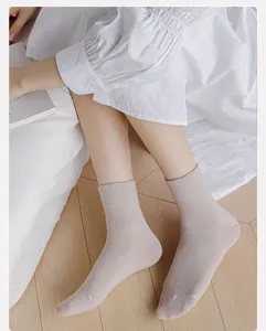Detail shot of solid color cotton mid-tube socks in milky white, cozy indoor lifestyle view.