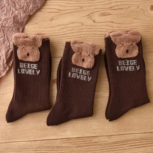 Brown plush bear mid-tube socks made of feather yarn, cozy winter fashion accessory.