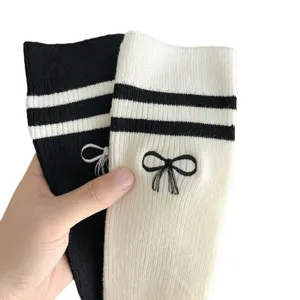 Nahaufnahme der JK-College-Socken mit süßer Schleifenstickerei und doppelten Streifen.