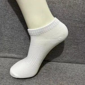 White short athletic socks detail view, breathable mesh weave fabric close-up display.